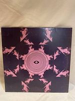Front cover of the Flume vinyl record featuring a dark, geometric and artistic pattern including repeated faces and an eye symbol in the center.