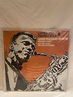 Front cover of the vinyl record sleeve showing a stylized black and white image of a saxophone player on an orange background titled Capitol Jazz Classics Vol 4 with artist and album details.