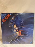 Front cover artwork showing vivid illustration of a stylized face in blue and orange tones with the band name 'Icon' in the top left corner.