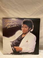 Front cover of Michael Jackson Thriller album in very good condition, showing Michael Jackson in a white suit against dark background.