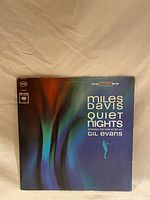 Front cover of the album 'Miles Davis Quiet Nights' arranged and conducted by Gil Evans, showing abstract artwork and album title.