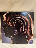 Front cover of the vinyl record album showing a layered silhouette profile artwork of band members