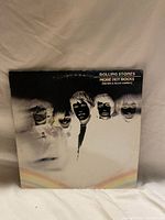 Front cover of the Rolling Stones vinyl album 'More Hot Rocks (Big Hits & Fast Rockin')' showing the band's inverted negative faces design with a rainbow detail at the bottom.