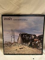Front of the vinyl LP cover showing 'Rush - A Farewell to Kings' album art featuring a ruined statue in a desolate landscape under a cloudy sky.
