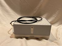 Front view of the Sonos ZP-100 digital music system showing the white perforated top panel and control button