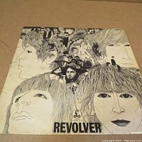 Front cover of Beatles Revolver LP showing illustrated faces of Beatles members.