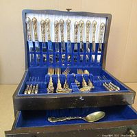 Full view of open canteen showing organized gilt silver plated flatware pieces in blue velvet lining.