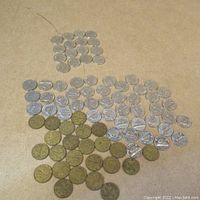 Overview of large group of Canadian 5 cent coins split into silver-colored nickels and older Tombac brass-like nickels.