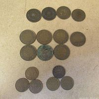 Top-down view of 17 one cent coins from Canada, Newfoundland, and PEI arranged on a surface.