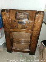 Full front view of walnut veneer radio cabinet showing grille and controls