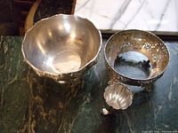 Top view of the set of three silver plate bowls on a marble surface.