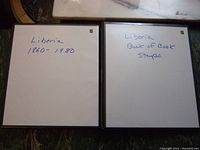 Photo of two closed stamp albums with handwritten labels 'Liberia 1860 - 1980' and 'Liberia Back of Book Stamps'