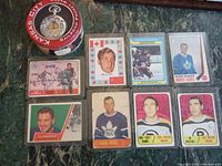 Kansas City Railroad railroad pocket watch in its round tin case and 8 vintage hockey cards displayed on surface