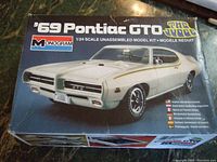 Front of box showing white 1969 Pontiac GTO model illustration and Monogram branding