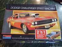 Front of Monogram model kit box featuring illustration of 1970 Dodge Challenger with hood scoop and large engine detail.