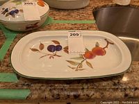 Top and side view showing full decoration of fruit cluster on the ceramic serving dish with green rim