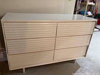 Front view showing slatted drawer fronts and two top half-width drawers