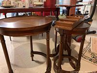 Set of three wooden side tables with turned legs and stretcher bases, showing wear and scratches.