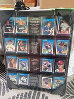 Full view of the sealed black plastic wall display showing 20 baseball player collector cards inside the card slots.