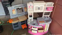 Kids play kitchen and kids tool bench side by side showing overall condition and setting