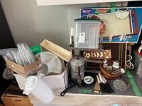 Full assortment of kitchen items including vintage coffee pot, knives, bowls, masher, containers, and spice rack on countertop.