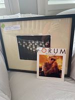 Framed black and white photograph of chess pieces arranged on a chessboard with artist proof label by Bruce Monk shown with Forum Hasselblad magazine.