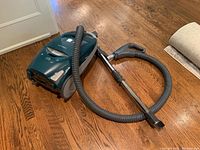 Full view of Kenmore Elegance PetHANDImate vacuum cleaner with hose and wand attachment on hardwood floor.