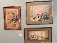Three framed Asian style art prints hanging on wall, showing floral and bird themes.