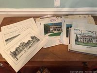 Stack of unframed art prints depicting historic homes and buildings along with envelopes for old Albany prints