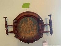 Front view of round solid wood coat hook with circular printed cloth artwork and multiple wooden hooks.