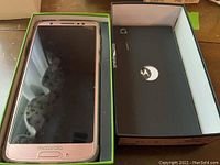 Close-up of one rose gold Motorola Moto G6 smartphone in original box with instruction manual and SIM ejector tool