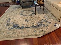 Full view of rug installed under living room furniture showing overall size, pattern and condition