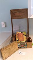 National Washboard Co. washboard with wooden frame, glass wash surface, and accompanying wooden Mason jar sign, Wayne County box, and small cookbook on a kitchen counter.