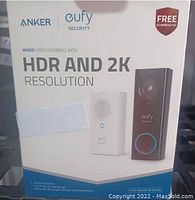 Photo showing the front of the product box displaying the Anker and Eufy Security branding, product image of the wired video doorbell and chime, key features such as 2K HDR resolution, free 10 month fee, and compatibility with Google Assistant and Amazon Alexa.