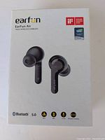 Front of the EarFun Air wireless earbud box showing earbuds, Bluetooth 5.0 logo, wireless charging, and waterproof features.