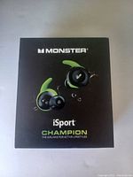 Front view of the Monster iSport Champion earbuds box showing product image and branding.
