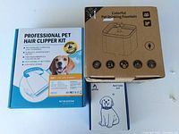Photo showing three boxed pet items: professional pet hair clipper kit, pet bark collar, and colorful pet drinking fountain.