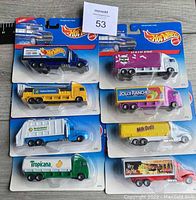 Front view of the eight unopened Hot Wheels Hauler trucks showing packaging and branding of each toy truck.