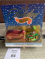 Front of the sealed packaging showing the Holiday Hot Wheels branding and the Kringle's Custom green car with Santa figure inside a clear display case.