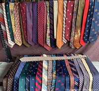 Upper row of ties in various colors and patterns, including stripes, solid colors, and animal motifs