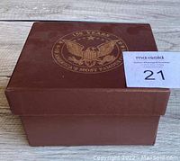 Brown box with embossed eagle and text