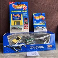 Photo showing all items together: Hot Wheels Computer Cars Rigor Motor disk and car, Hot Wheels Treasure Hunt disk and car, and Four Decades of Pony Power boxed set of three cars.