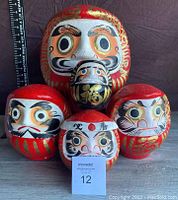 Photo of five Daruma dolls arranged in a group showing all sizes and styles