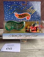 Front view of the unopened Holiday Hot Wheels North Pole Engine 1997 special edition collectible in original packaging with green Hot Wheels ornament.