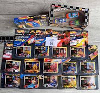 Front view of 19 packaged Hot Wheels Pro Racing NASCAR die-cast cars with trading cards, plus 2-car Speedway set and racing videotape in packaging.