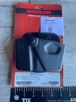 Front view of Safariland 573 open top magazine and handcuff pouch on original packaging with product label and barcode visible.