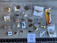 Various hat pins, tie pins, tie bars, and collectible pins displayed on a surface