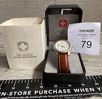 Wenger Swiss Army watch with brown leather band in open black presentation box and outer white box with Swiss Army logo.