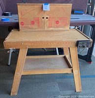Frontal photo of a wooden boys workbench showing measurement markings and upper panel with printed tool graphics