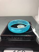 Close-up of blue amazonite gemstone bangle resting on a digital scale showing weight.
